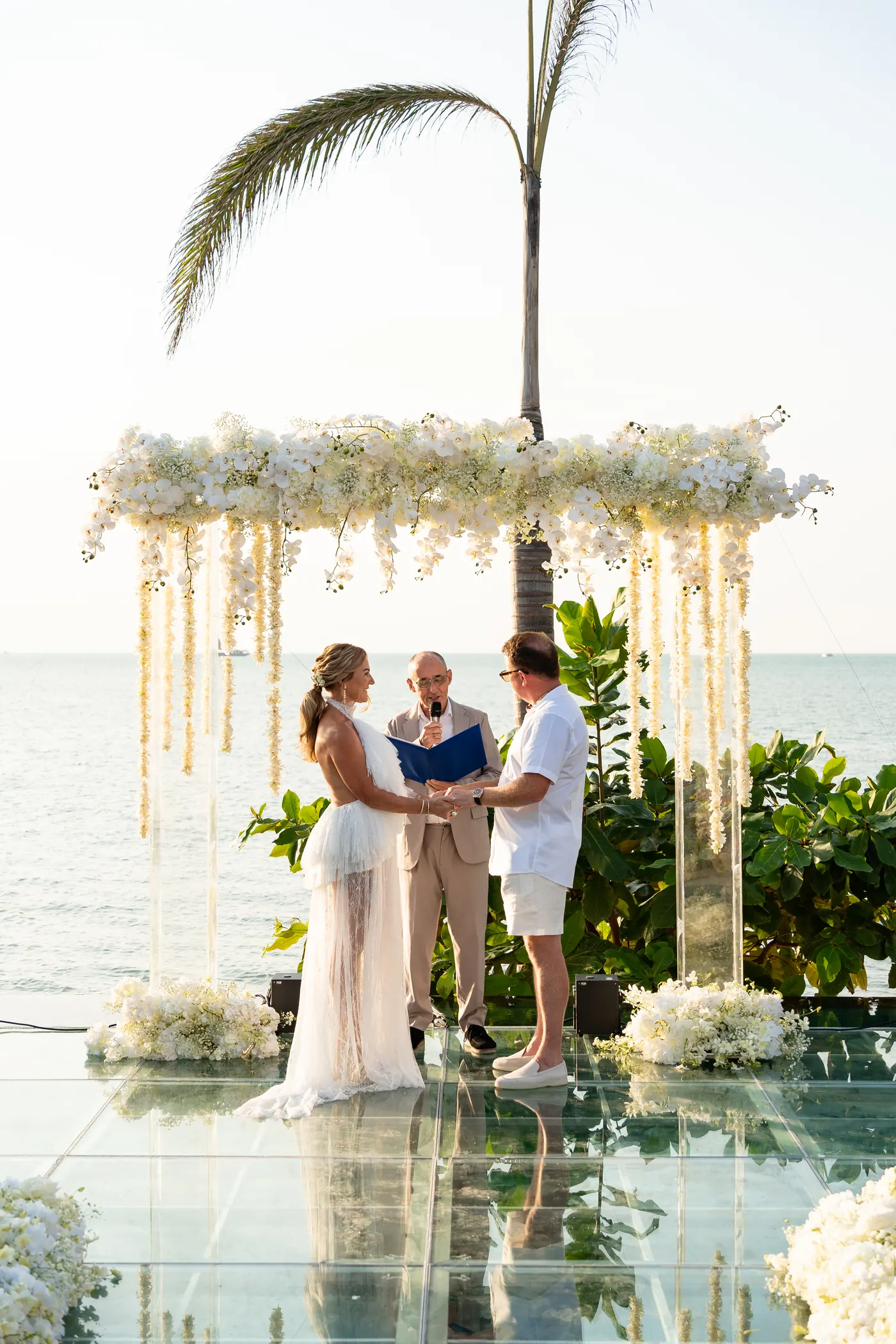 Wedding ceremony under a floral arch over the water, Koh Samui