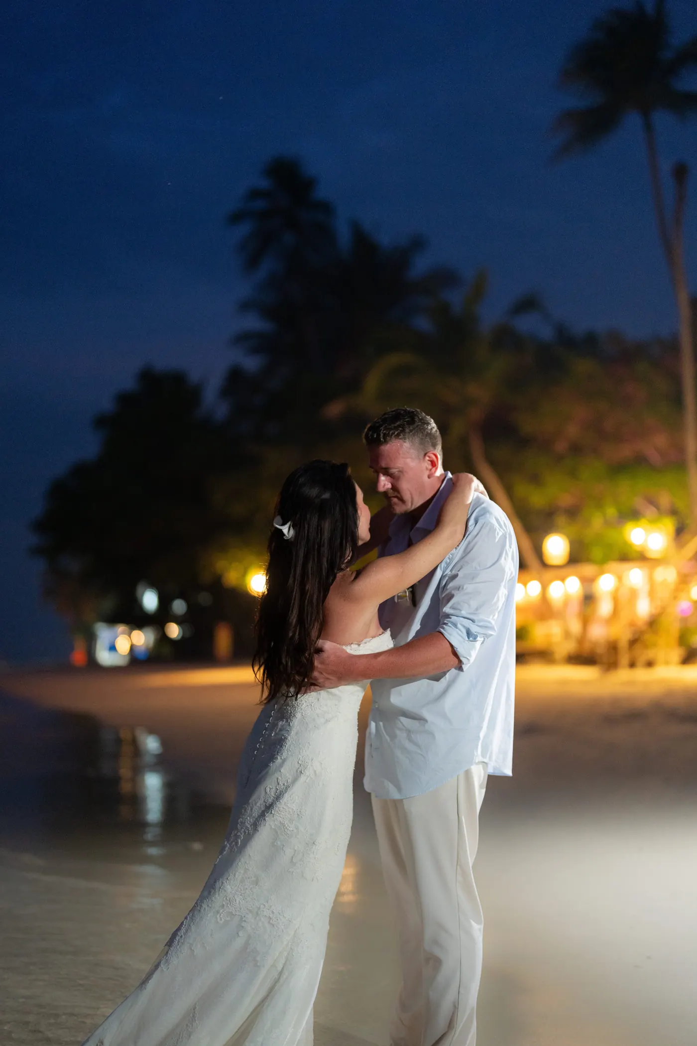 Bride and groom dancing on the beach at night