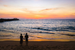 Couple watching sunset at the beach